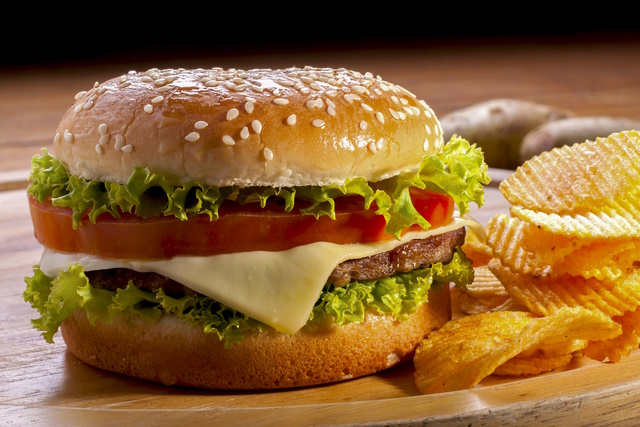 Burger with chips on wooden plates,and black background.