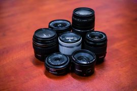 A closeup of a group of 7 Canon lenses on a desk in a circle