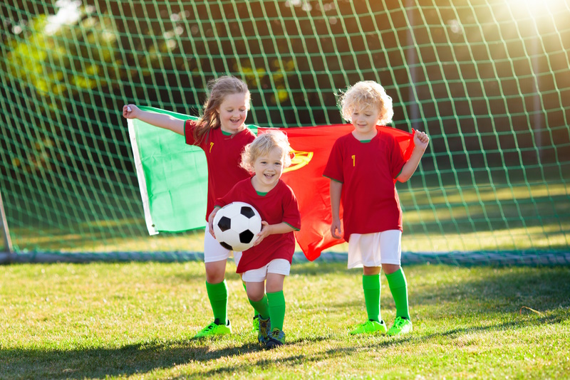 Creative Family Photoshoot Ideas - Kids play football on outdoor field.