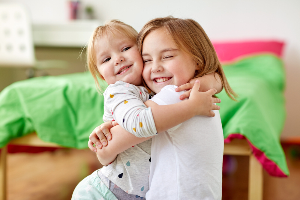 Creative Family Photoshoot Ideas - happy little sisters hugging at home