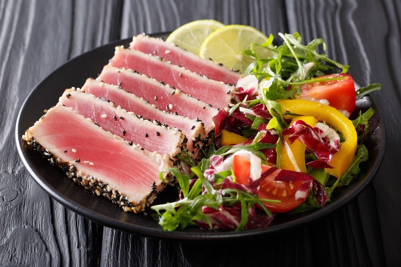 steak tuna in sesame, lime and fresh salad close-up on a plate on the table. horizontal