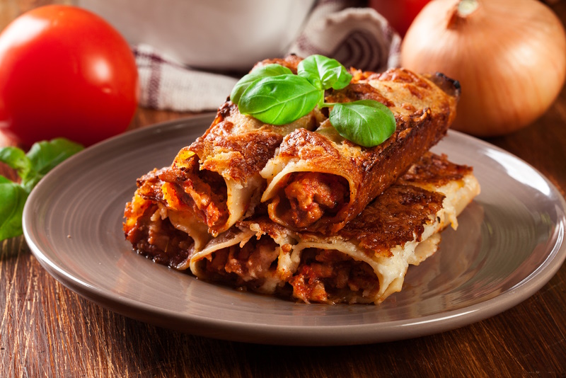 Baked cannelloni with minced meat and bechamel sauce on a plate. Italian cuisine