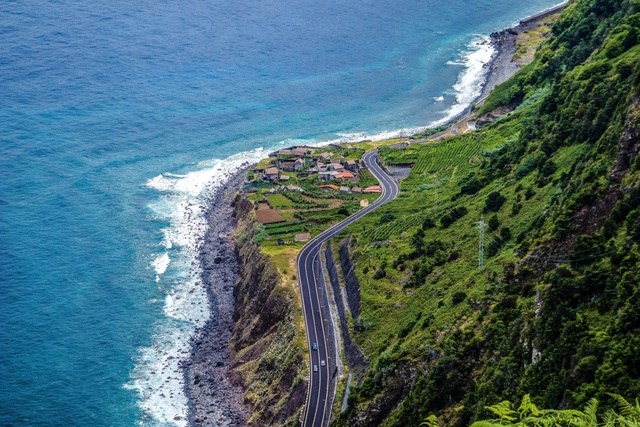 An aerial photography shot of a highway in the mountains on the shore of Madeira