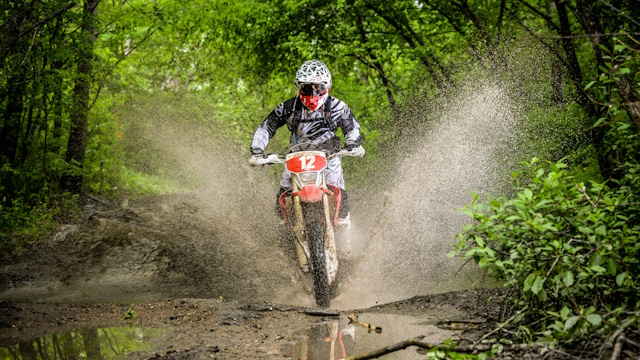 Alpine skier skiing downhill, blue sky on background - Khabarovsk, Russia - may 30. 2016 : unknown rider in action on stage Enduro Khabarovsk . Motorcyclists ride in the mud with a big splash